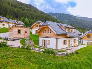 un grupo de casas de madera en un campo con montañas en Haus Hestia, en Donnersbachwald