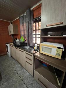 una cucina con forno a microonde sopra un bancone di FLAT - ALUGO POR DIAS - Sua casa de praia te espera! a Balneário Barra do Sul Altre 10 foto