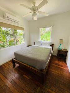 プラヤ・エルモサにあるCosta Rica Beach Bungalowのベッドと天井扇風機のある寝室