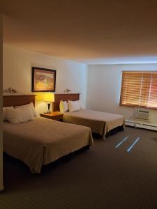 a hotel room with two beds and a window at Wildwood Hotel in Wildwood