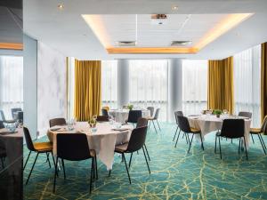 a conference room with tables and chairs and windows at Novotel Paris 17 in Paris