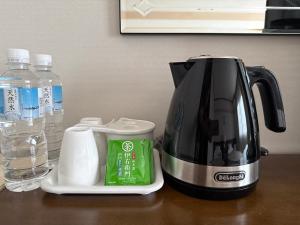a coffee maker sitting on a table next to a bottle of water at マウンテンリゾート・マルガンタ Marganta in Madarao Kogen