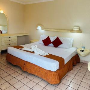 a bedroom with a large bed with red pillows at Hotel Hacienda del Rio Oaxtepec in Pantitlán +30 photos