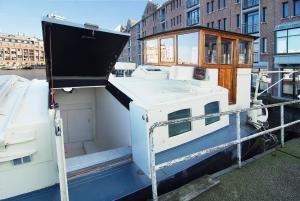 un pequeño barco sentado en un cuerpo de agua en Najade Eco Houseboat, en Ámsterdam