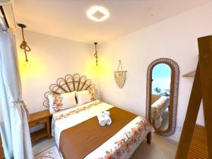 une chambre avec un lit et un miroir dans l'établissement Flat Centro de Buzios, à Búzios