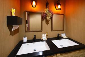 2 lavabos blancos en un baño con 2 espejos en Lodge Iwakura Yamato, en Katashina