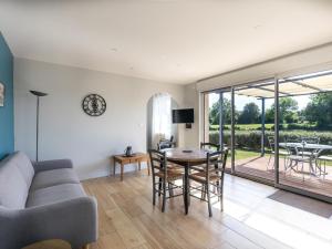 a living room with a couch and a table and chairs at Gîte de Charme : Calme, Nature, Proche du Mans, Terrasse, Jardin, Parking Privé - FR-1-410-397 in Montbizot