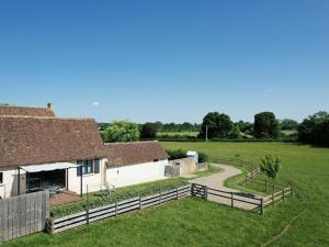 a farm building with a fence and a grass field at Gîte de Charme : Calme, Nature, Proche du Mans, Terrasse, Jardin, Parking Privé - FR-1-410-397 in Montbizot