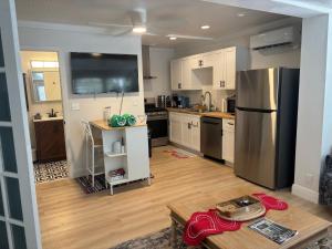 une cuisine avec un réfrigérateur en acier inoxydable et du parquet dans l'établissement Seaside Retreat Cottages #3, à Clearwater Beach