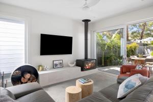 Una sala de estar con chimenea y televisión. en The Watermark, en Narrawallee