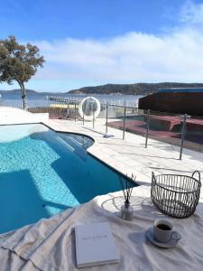 a table with a cup of coffee next to a swimming pool at Bluewater sanctuary in Tascott