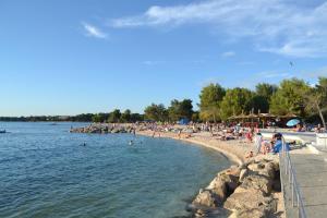 a beach with a bunch of people on the water at Viola Istra Guest House in Štinjan