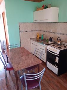 eine Küche mit Tisch, Spüle und Herd in der Unterkunft RuralEsquina in Esquina