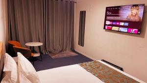 a hotel room with a bed and a tv on the wall at Vienna Motel in Paihia