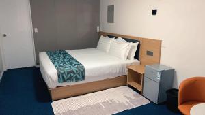 a hotel room with a bed and a chair at Vienna Motel in Paihia