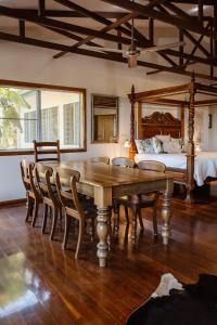 a dining room with a wooden table and a bed at Wybalena ocean views tropical big home garden pool in Port Douglas