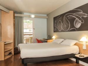 a hotel room with a large bed and a window at ibis La Bresse Gérardmer in La Bresse +122 photos