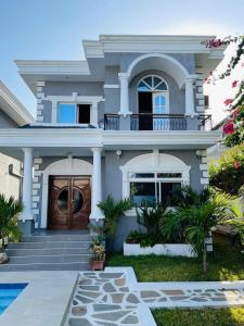 a house with a front door and a yard at Rise&shinevillarosa in Watamu