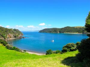 a view of a beach with a boat in the water at Vienna Motel in Paihia