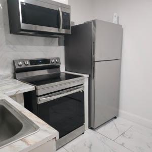 タンパにあるAraly's houseのキッチン(コンロ、電子レンジ、冷蔵庫付)