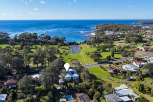 an aerial view of a suburb with the ocean at Ahgunyah Beach House in Mollymook