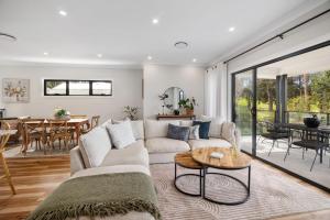 a living room with a couch and a table at Ahgunyah Beach House in Mollymook