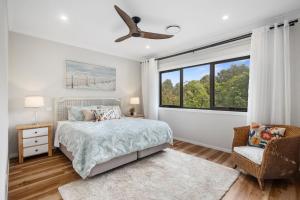 a bedroom with a bed and a window at Ahgunyah Beach House in Mollymook