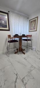 a dining room with a wooden table and two chairs at Araly's house in Tampa +13 photos