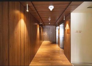 a hallway with wooden walls and a hallway with a light on the ceiling at The Opal residence IBR in Sharjah +14 photos