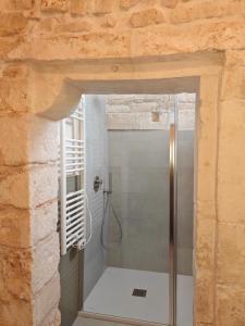 ein Bad mit einer Dusche in einer Steinwand in der Unterkunft Old Town Suite Martina in Martina Franca