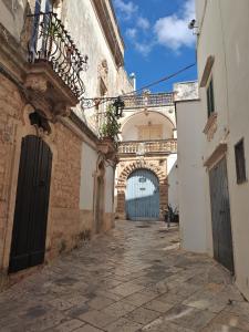 eine Gasse mit einem Torbogen und ein Gebäude mit einem Balkon in der Unterkunft Old Town Suite Martina in Martina Franca