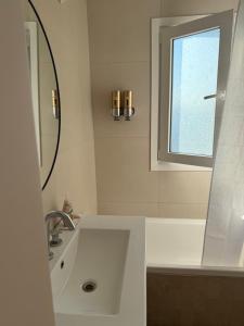 a white bathroom with a sink and a window at Alquiler depto olavarria in Olavarría