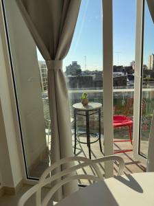 a room with a balcony with a table and a window at Alquiler depto olavarria in Olavarría +1 photo