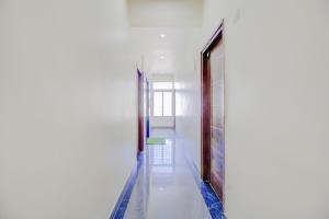 un pasillo con una puerta y un taburete verde en Hotel O Nelli Suites, en Bangalore
