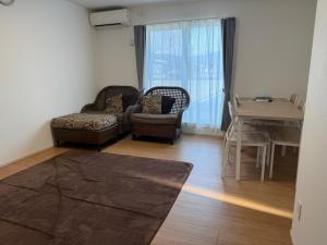 a living room with a couch and chairs and a table at にじいろ邸2階 in Fujiyoshida