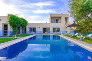 a large swimming pool in front of a house at Villa de Luxe à Marrakech avec Piscine Chauffée Privée in Aghmat
