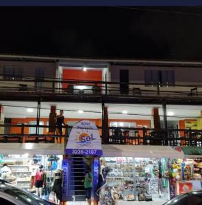 Ein Geschäft, vor dem nachts Menschen stehen. in der Unterkunft Hotel Pousada Sol Beira-mar in Natal