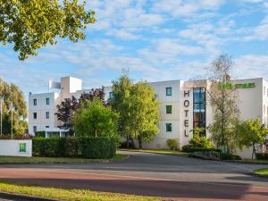 a white building with a road in front of it at Ibis Styles Cognac in Châteaubernard