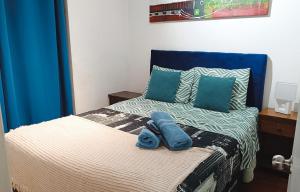a bedroom with a bed with blue towels on it at Departamentos Home Bulnes in Santiago