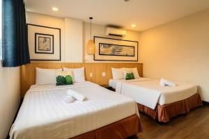 a hotel room with two beds with white sheets at Hoang Phi Saigon Hotel & Spa in Ho Chi Minh City +16 photos