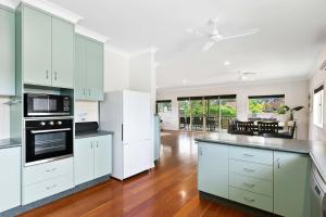 a kitchen with white cabinets and a counter top at Coastal Bliss - 3 Beds Holiday House in Burrum Heads
