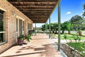 a patio with a wooden pergola on a house at Coastal Bliss - 3 Beds Holiday House in Burrum Heads