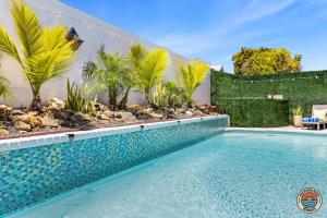 een zwembad in een tuin met palmbomen bij 4BR Chula Vista Getaway Splash, Play & Game! in Chula Vista