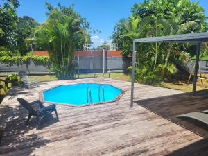 a swimming pool in a yard with a chair at Villa du FORT in Goyave