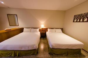 Voodi või voodid majutusasutuse Palm Tree Hotel Kenting toas