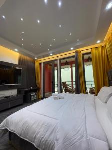 una camera da letto con un grande letto bianco e una televisione di Shapes Beach House a Kokrobite