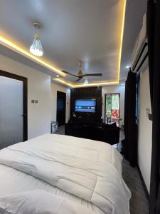 una camera con letto bianco e TV a schermo piatto di Shapes Beach House a Kokrobite 1 altra foto