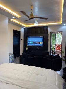una camera da letto con un letto e una TV a schermo piatto di Shapes Beach House a Kokrobite