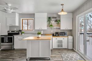 une cuisine avec des armoires blanches et un comptoir en bois dans l'établissement Lakefront Cabin - Cozy Retreat - 5Beds - TV - Wifi, à Barrhead