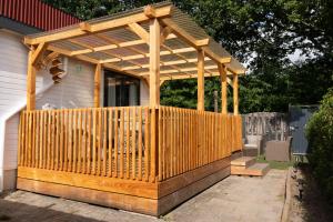 a wooden pergola on the side of a house at Chalet de Bosrand in Anloo